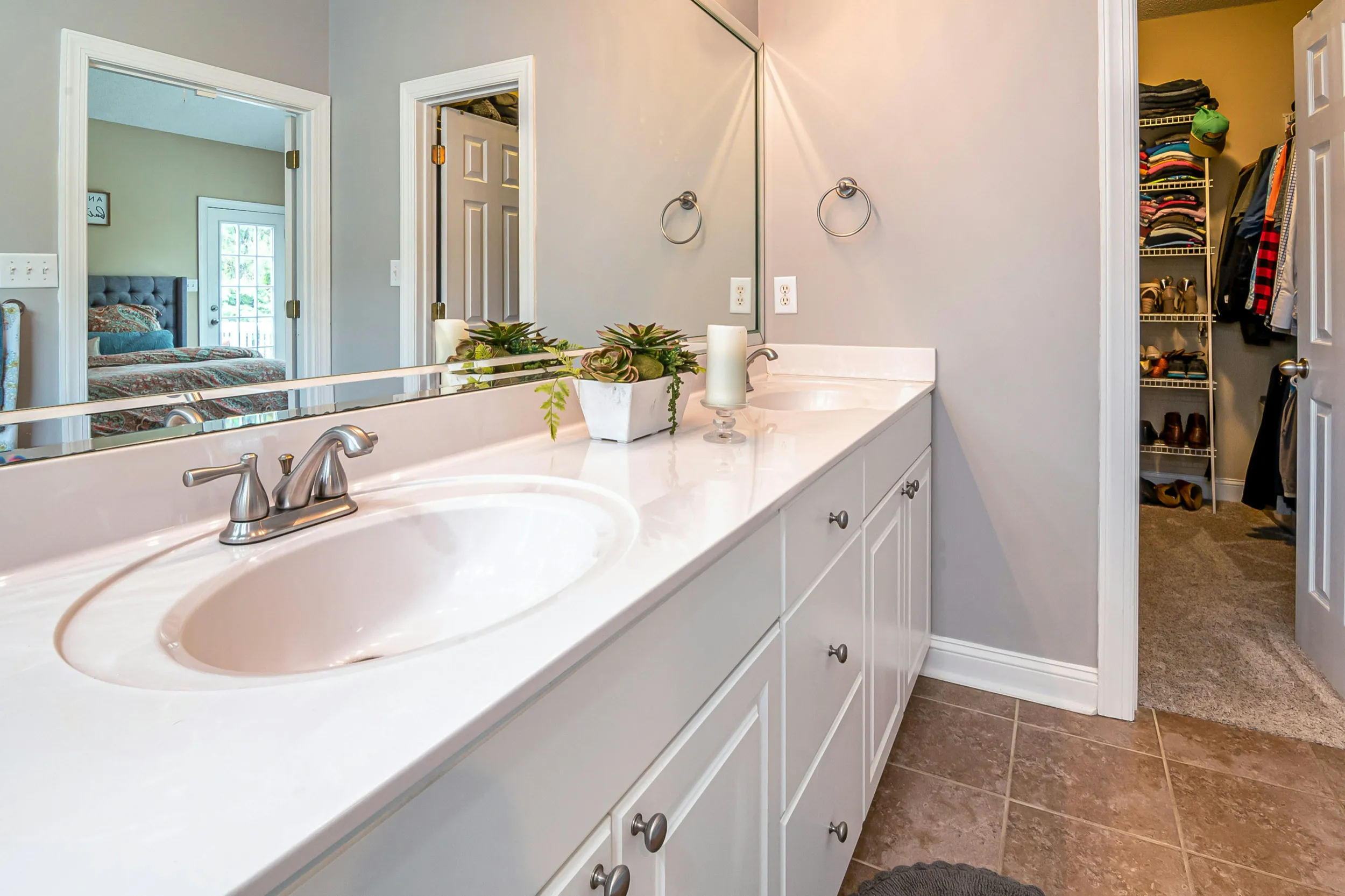 Ljust och rymligt badrum i Höllviken med dubbla handfat, stor spegel och vit inredning efter renovering.